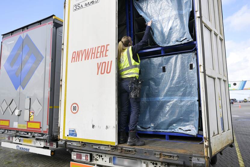 Vrouw controleert vrachtwagenlading voor de Douane
